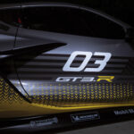 Close up view of decals on passenger side door of 2024 Chevrolet Corvette Z06 GT3.R in spotlight. Pre-production model shown. Actual production model may vary. Model year 2024 Corvette Z06 GT3.R will be available later this year.
